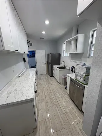 a kitchen with stainless steel appliances granite countertop a sink a stove and a refrigerator