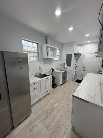 a large white kitchen with cabinets appliances and a window