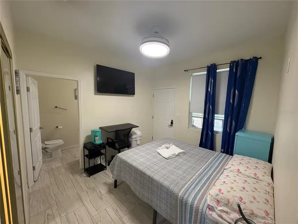 a bedroom with a bed and a television