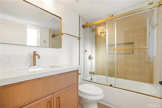 a bathroom with a shower sink vanity mirror and toilet