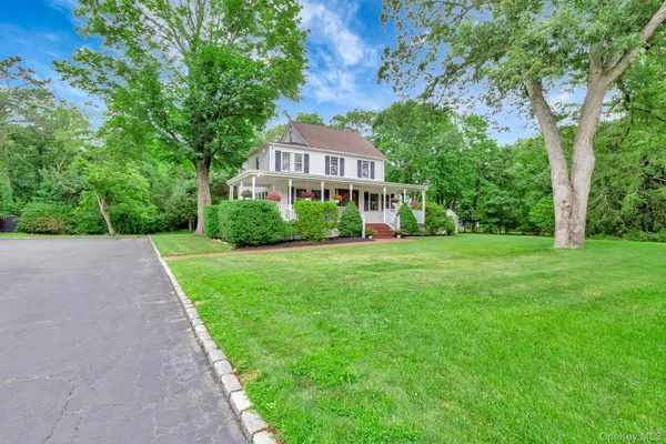 a front view of a house with yard and tree