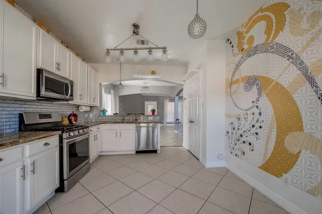 a kitchen with cabinets appliances a sink and a counter top space