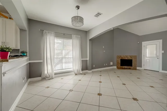 an empty room with windows and fireplace