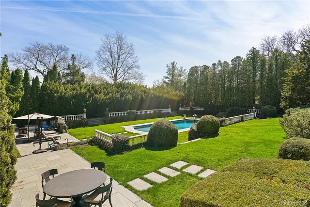 a view of backyard with swimming pool and seating space