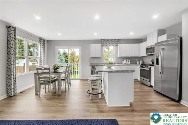 a kitchen with a table chairs refrigerator microwave and cabinets