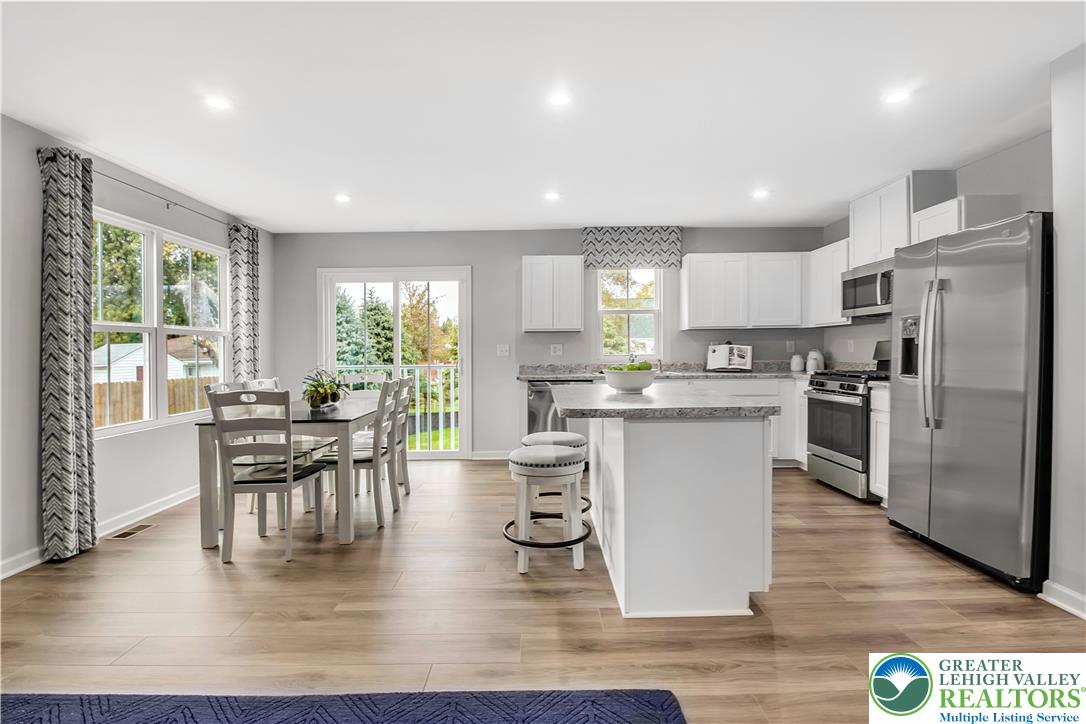 a kitchen with a table chairs refrigerator microwave and cabinets
