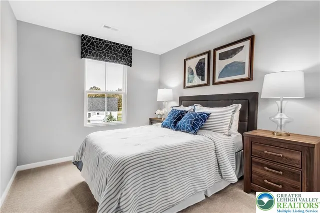 a bedroom with a bed and a lamp on dresser