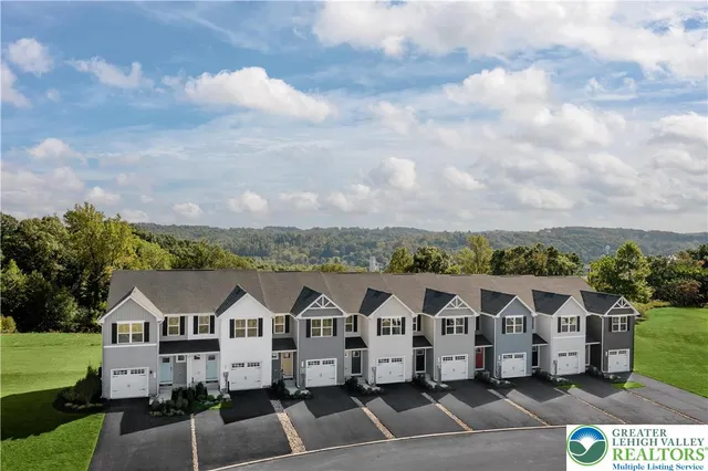 a view of a white house with a yard and balcony
