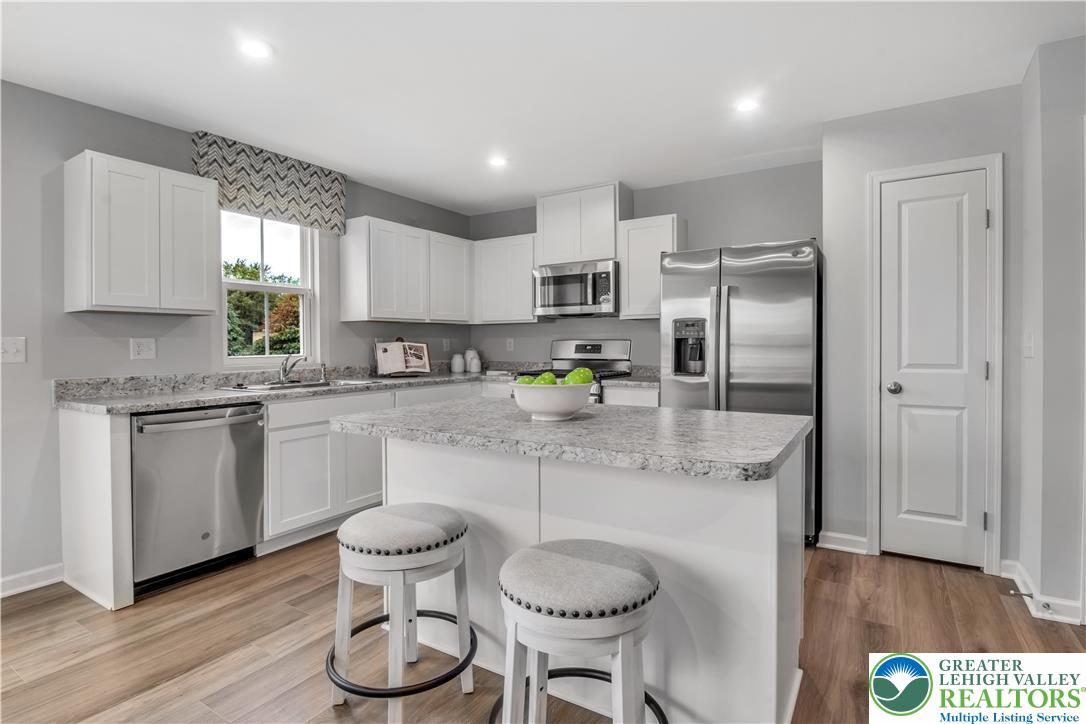 1 Shiloh Road, Unit P Orwigsburg, PA 17961 - Photo 7 of 15 a kitchen with stainless steel appliances granite countertop a refrigerator a sink dishwasher a stove and white cabinets with wooden floor