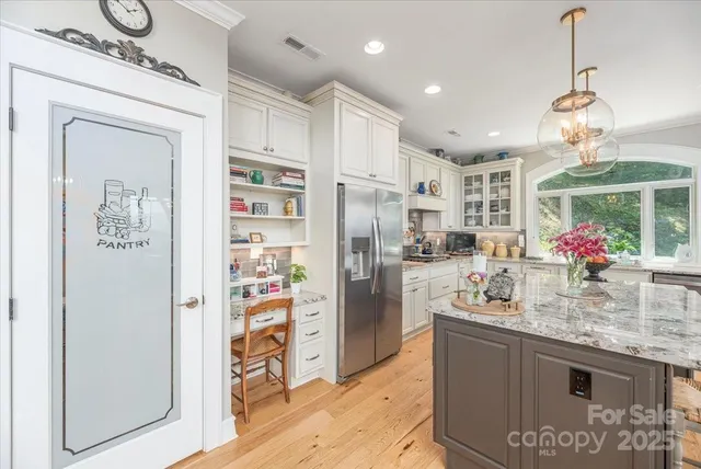 a kitchen with stainless steel appliances granite countertop a refrigerator and a stove top oven