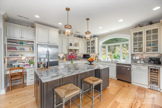 a kitchen with stainless steel appliances granite countertop a kitchen island a stove and a refrigerator