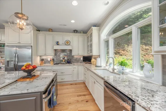 a kitchen with stainless steel appliances granite countertop a sink stove and cabinets