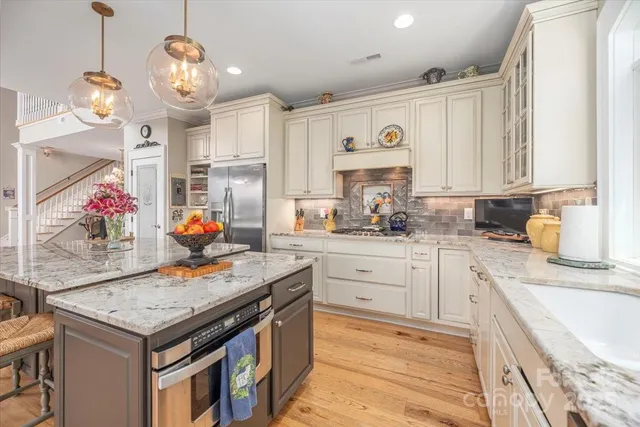 a kitchen with stainless steel appliances granite countertop a stove and cabinets