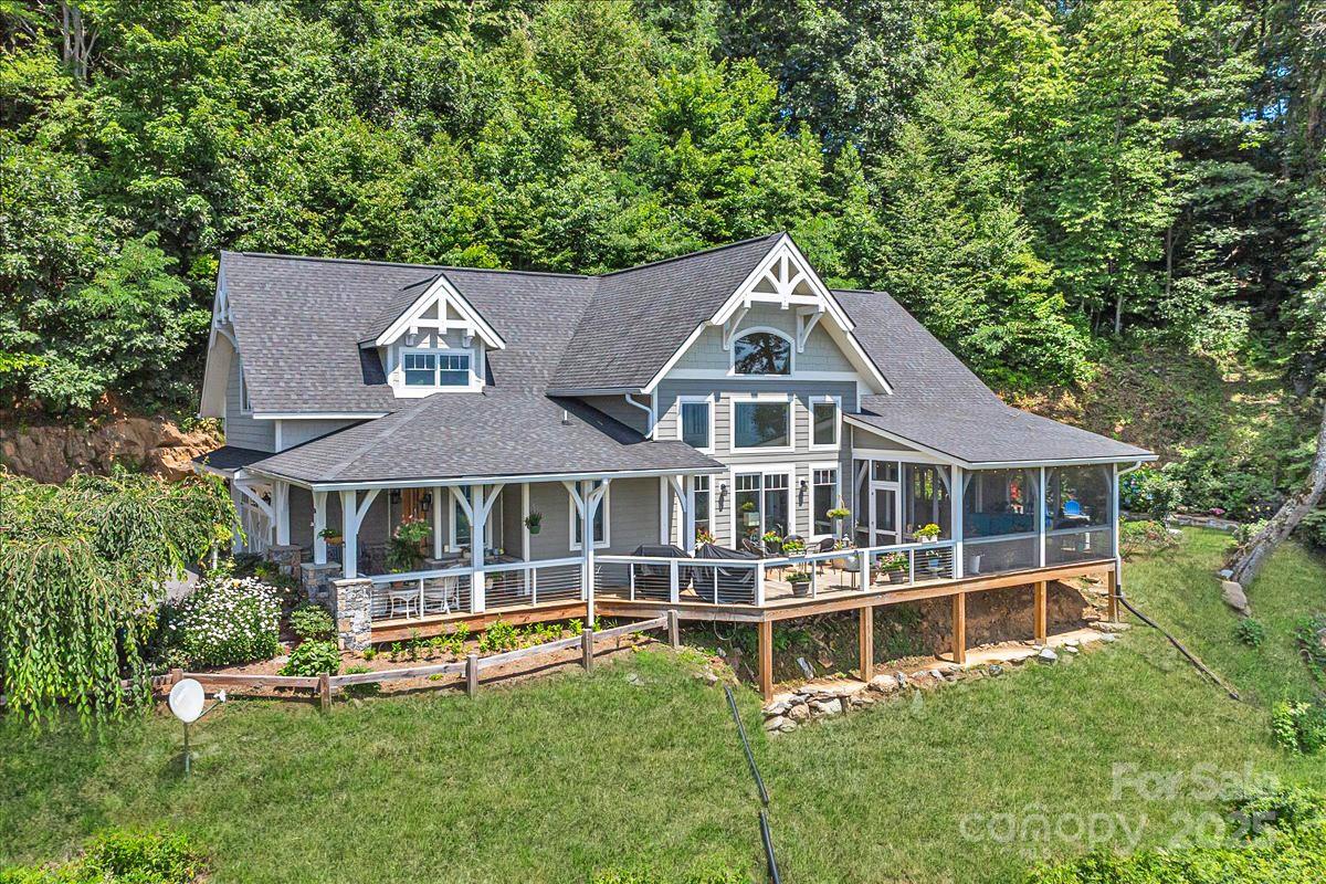 316 Fincher Mountain Road Waynesville, NC 28785 - Photo 2 of 46 a front view of a house with a yard table and chairs under an umbrella