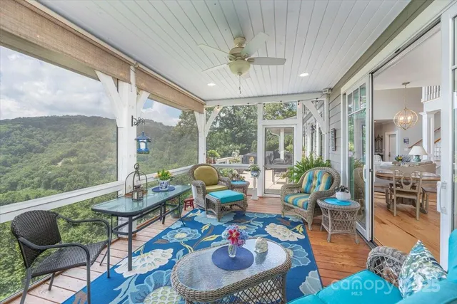 a view of a balcony with chairs potted plants and wooden floor