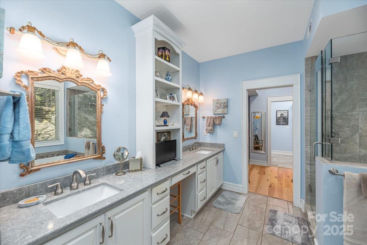 316 Fincher Mountain Road Waynesville, NC 28785 - Photo 30 of 46 a spacious bathroom with a granite countertop sink mirror and shower