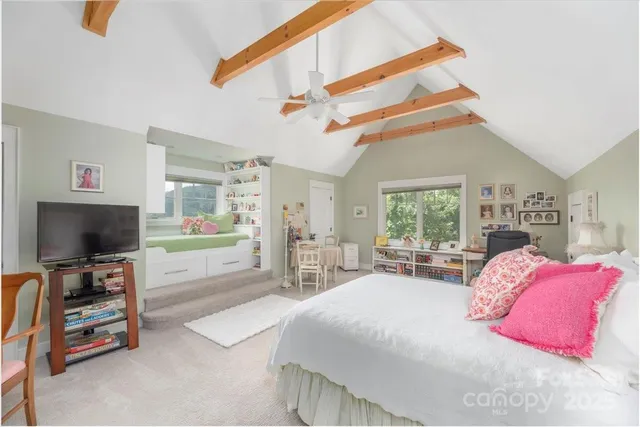 a bedroom with a bed a chandelier and dresser