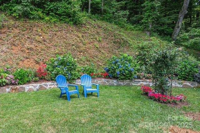 a front view of house with yard and trees in the background