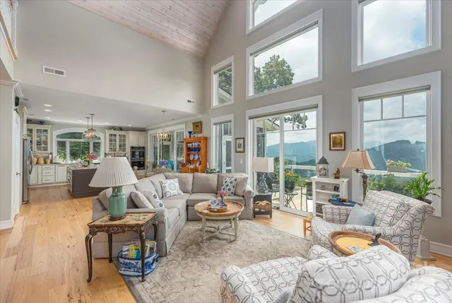 a living room with fireplace furniture and a large window