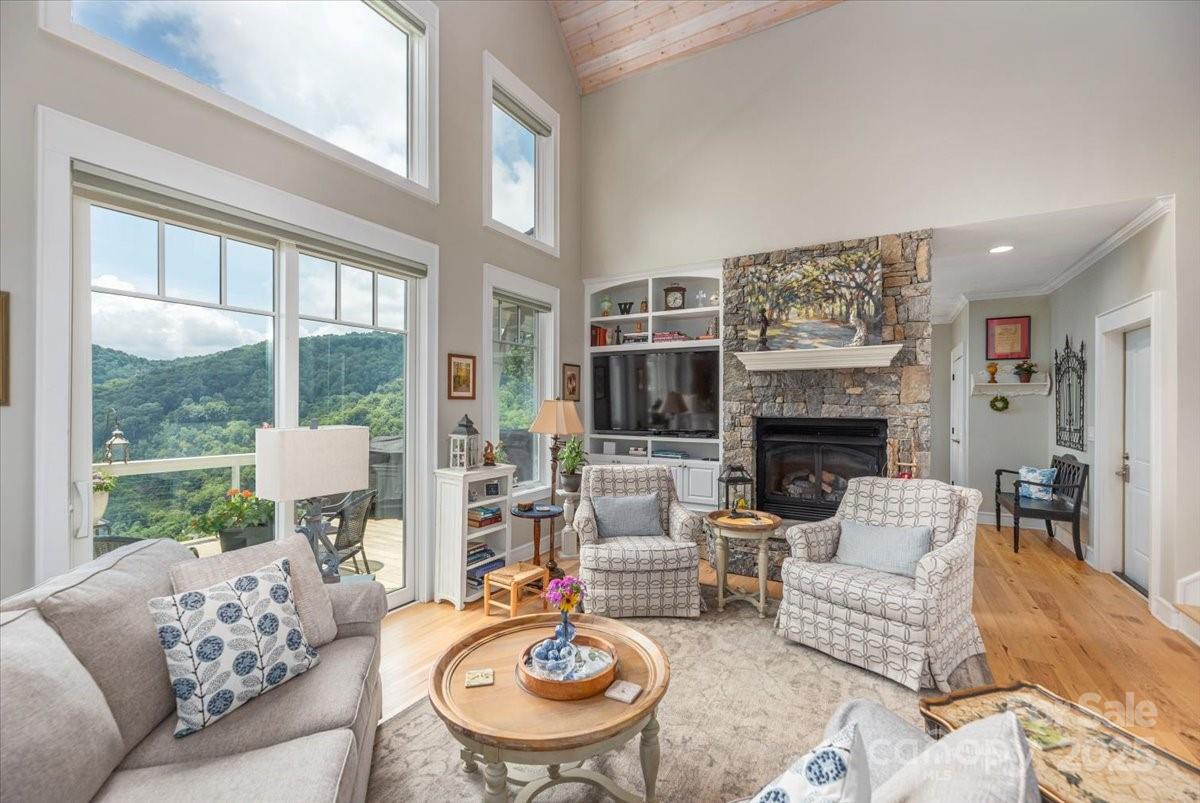 316 Fincher Mountain Road Waynesville, NC 28785 - Photo 10 of 46 a living room with furniture a fireplace and a large window
