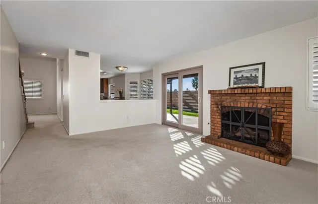 a view of a livingroom with a fireplace and window
