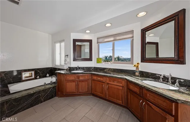 a bathroom with a granite countertop sink a window and shower