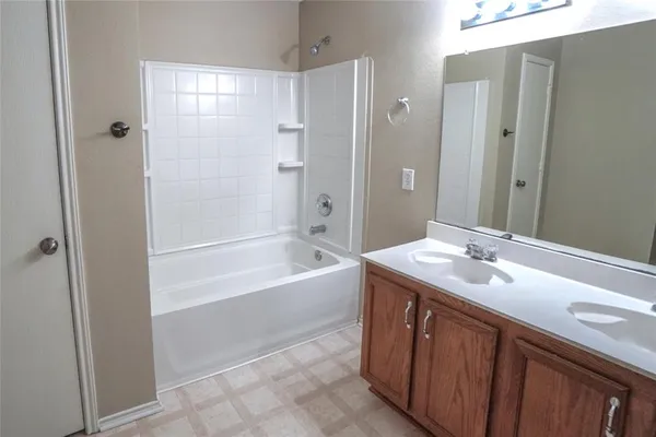 a bathroom with a tub sink and mirror