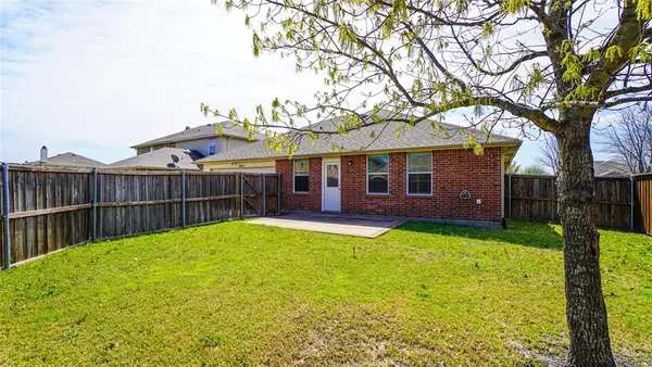a view of a house with backyard and a tree