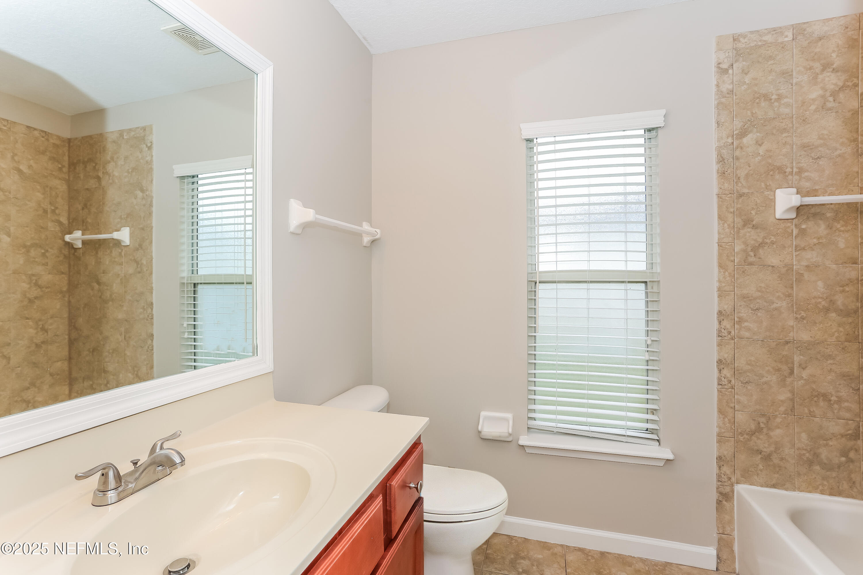 86016 Cherry Laurel Way Yulee, FL 32097 - Photo 13 of 15 a bathroom with a sink a toilet and tub