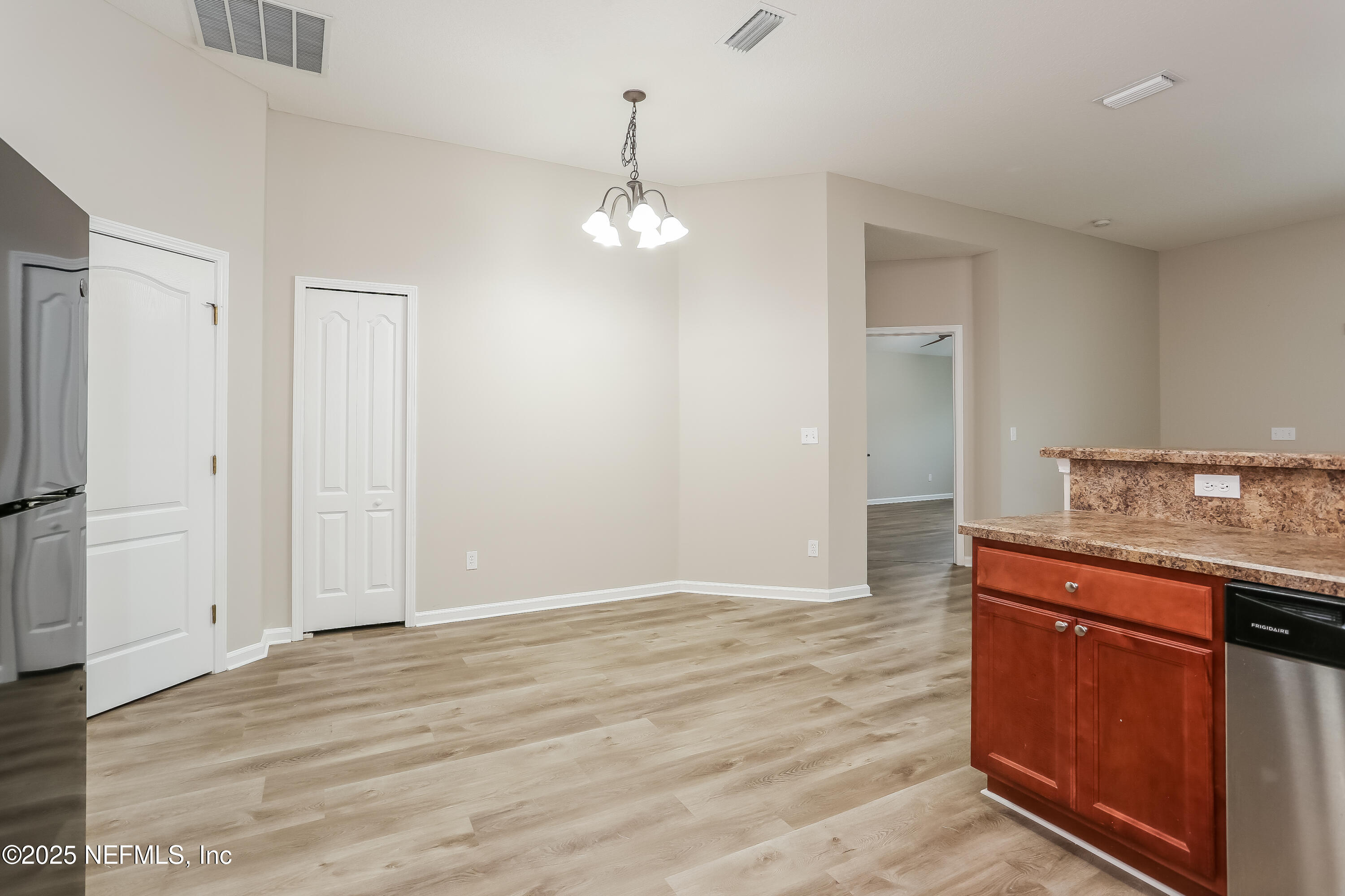 86016 Cherry Laurel Way Yulee, FL 32097 - Photo 6 of 15 an empty room with wooden floor and cabinet