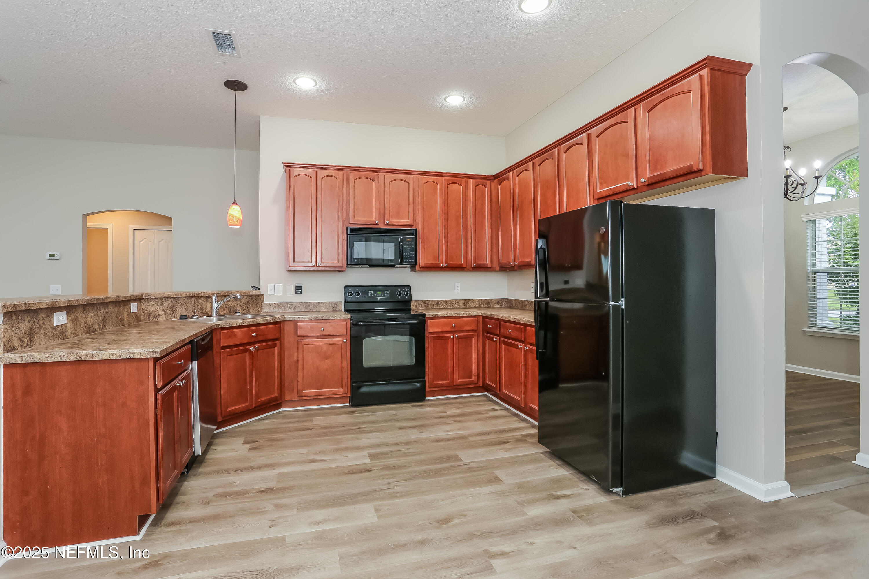 86016 Cherry Laurel Way Yulee, FL 32097 - Photo 7 of 15 a kitchen with stainless steel appliances wooden cabinets a sink and a refrigerator