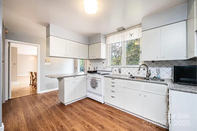 a kitchen with granite countertop white cabinets and white appliances