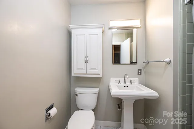 a bathroom with a toilet sink and mirror