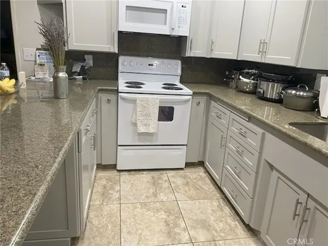 a kitchen with a stove top oven and cabinets