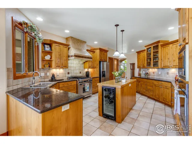 a kitchen with stainless steel appliances granite countertop a sink a stove and a refrigerator