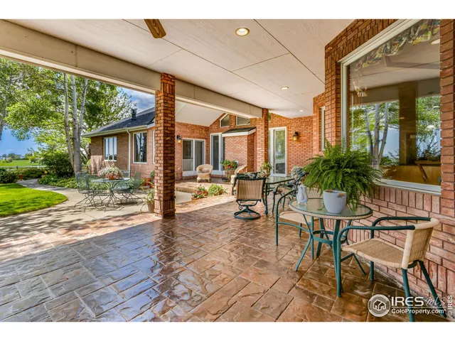 a view of a patio with table and chairs potted plants with wooden floor and fence