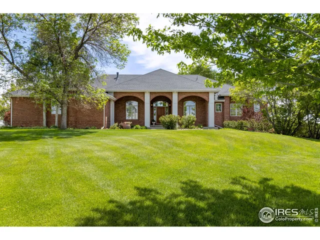 a front view of house with yard and trees in the background