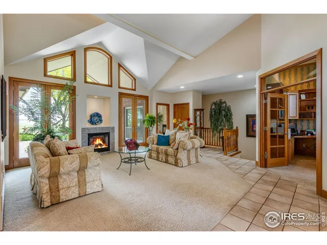 a living room with furniture a fireplace and large windows