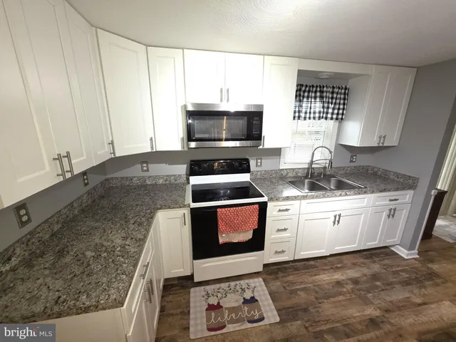 a kitchen with a stove a sink and a microwave