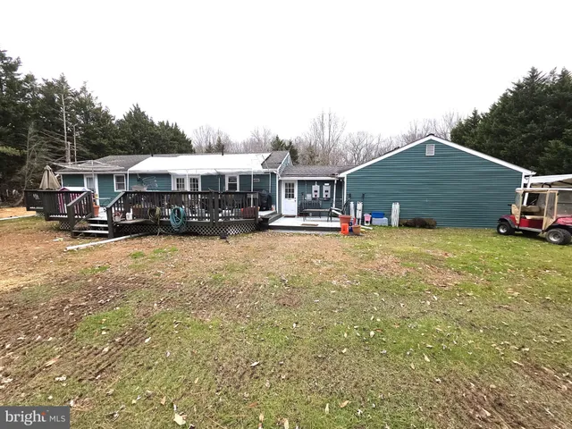 a view of a house with a big yard and large trees