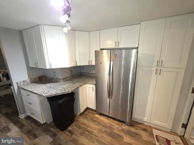 a kitchen with granite countertop a refrigerator and a sink