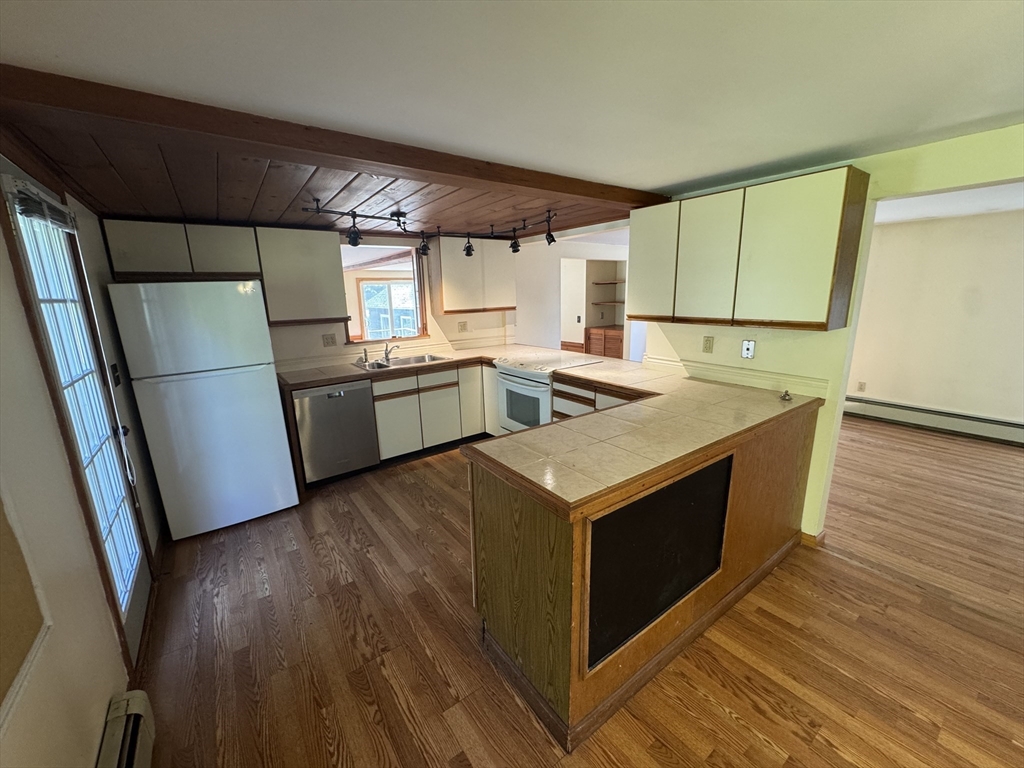 28 Lindbergh Street Clinton, MA 01510 - Photo 16 of 27 a kitchen with wooden cabinets a sink a stove a refrigerator and a window
