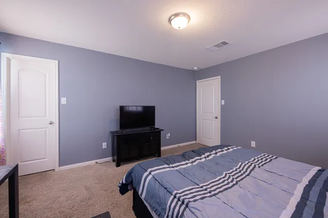 a bedroom with a bed and a flat screen tv