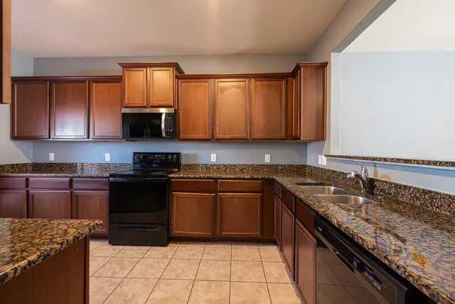a kitchen with stainless steel appliances granite countertop a sink stove and microwave