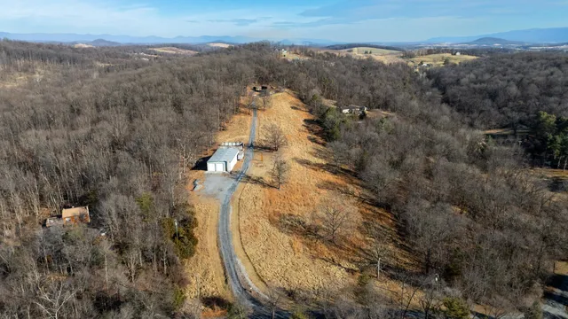 an aerial view of house with yard and mountain view in back