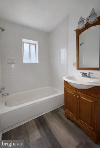 a bathroom with a bathtub sink and mirror