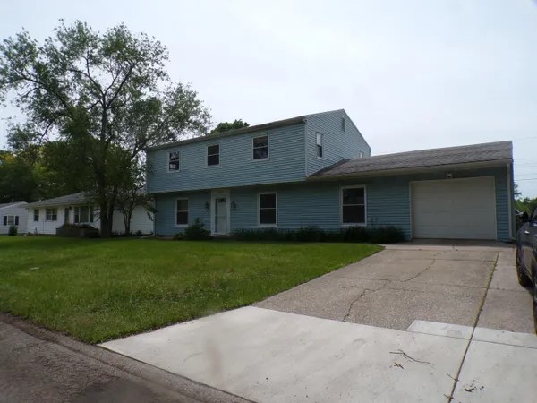 a front view of a house with a yard and trees
