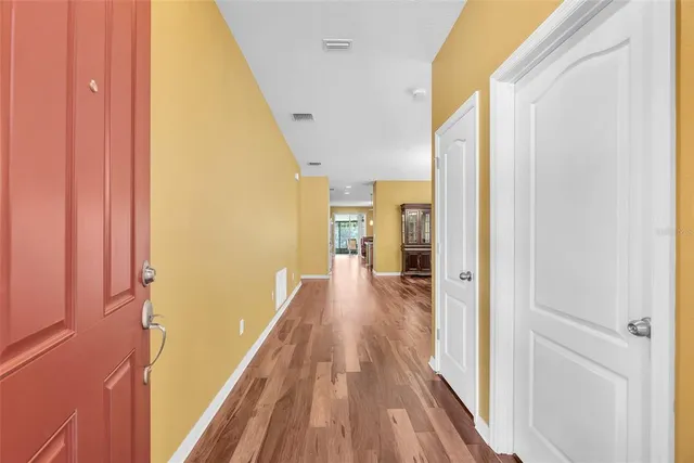 a view of a hallway with wooden floor and staircase