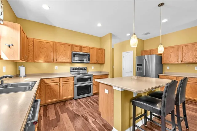a living room with furniture a wooden floor and a kitchen view