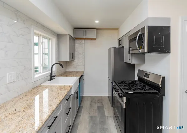 a kitchen with stainless steel appliances granite countertop a sink stove and refrigerator